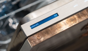 A close-up of a dishwasher control panel showing a blue display that reads "sabbath on," with part of the dishwasher's interior visible in the background.